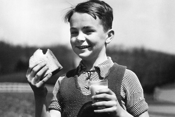 Boy eating a sandwich, 1940s